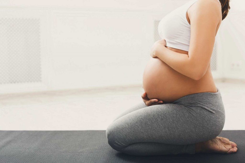 Femme enceinte en tenue de yoga postnatal et prenatal